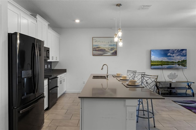 kitchen featuring white cabinetry, sink, black appliances, a kitchen breakfast bar, and an island with sink