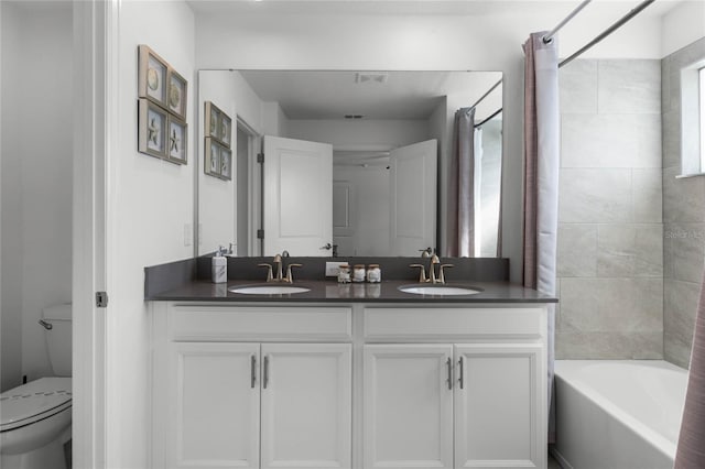 full bathroom with toilet, vanity, and tiled shower / bath