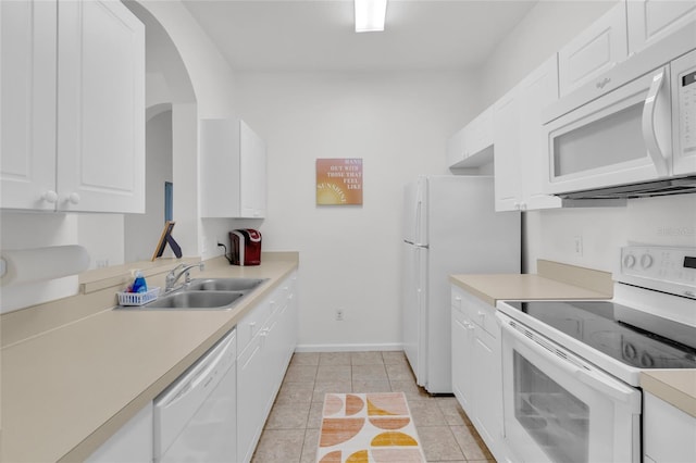 kitchen featuring sink, white cabinets, light tile patterned flooring, and white appliances