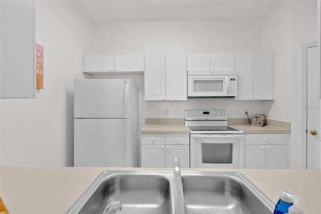 kitchen featuring white appliances, white cabinetry, and sink