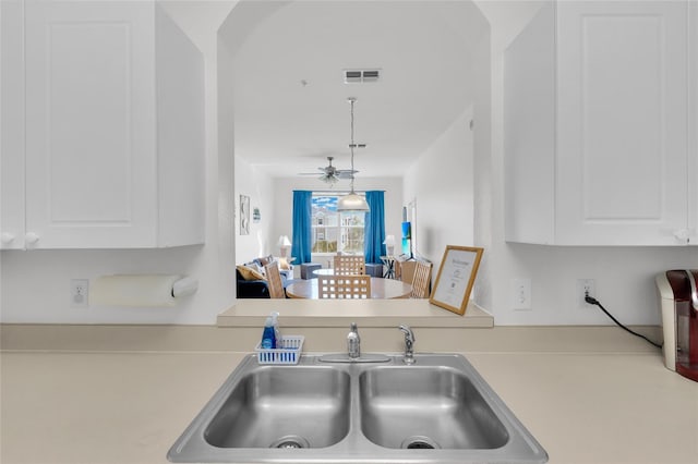 kitchen featuring white cabinetry, sink, ceiling fan, and hanging light fixtures