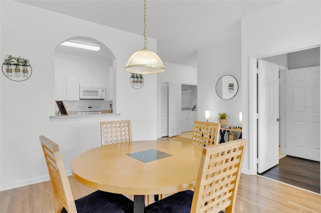 dining area with wood-type flooring and separate washer and dryer