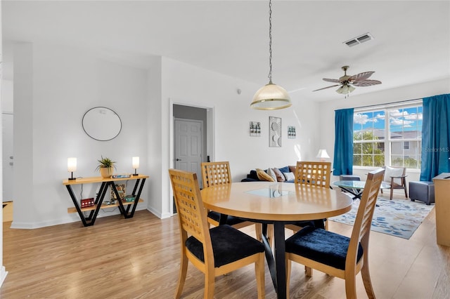 dining space with ceiling fan and light hardwood / wood-style floors