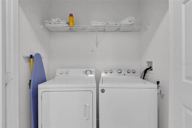 clothes washing area with washing machine and dryer