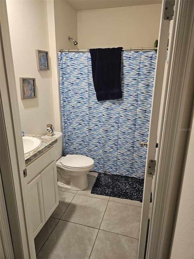 bathroom with tile patterned flooring, vanity, toilet, and a shower with curtain