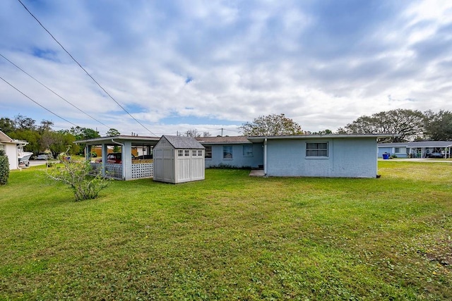 rear view of house with a storage unit and a lawn