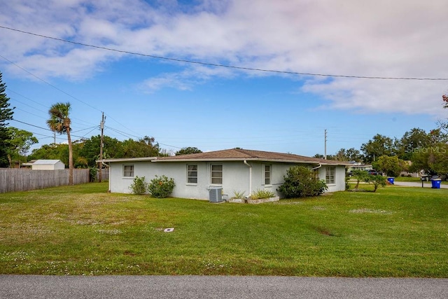 exterior space with central AC and a front yard