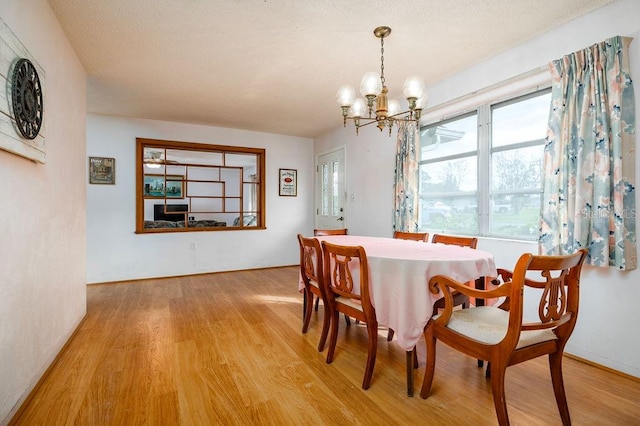 dining area with hardwood / wood-style floors and a notable chandelier