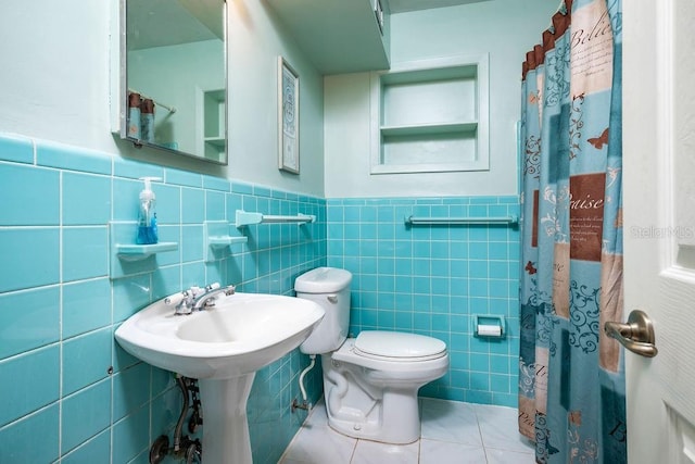 bathroom with tile patterned flooring, toilet, and tile walls