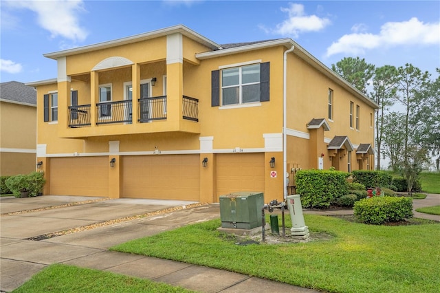 view of front of home with a garage, a front yard, and a balcony