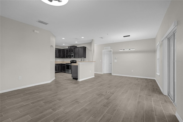 unfurnished living room featuring hardwood / wood-style flooring and sink