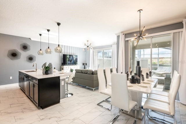 kitchen with a chandelier, plenty of natural light, sink, and pendant lighting