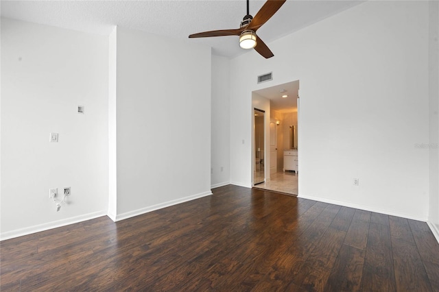 empty room with a textured ceiling, dark wood-type flooring, and ceiling fan