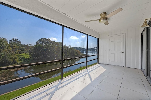 unfurnished sunroom with a water view and ceiling fan