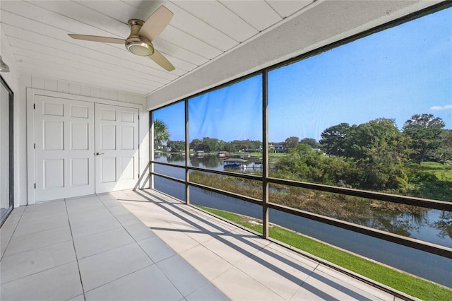 unfurnished sunroom with a water view, wooden ceiling, and ceiling fan