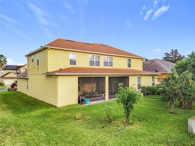 rear view of house featuring a sunroom and a lawn