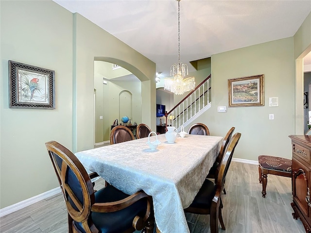 dining space featuring light hardwood / wood-style floors and a chandelier