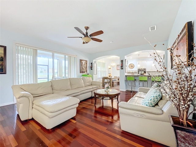 living room with ceiling fan and dark hardwood / wood-style floors