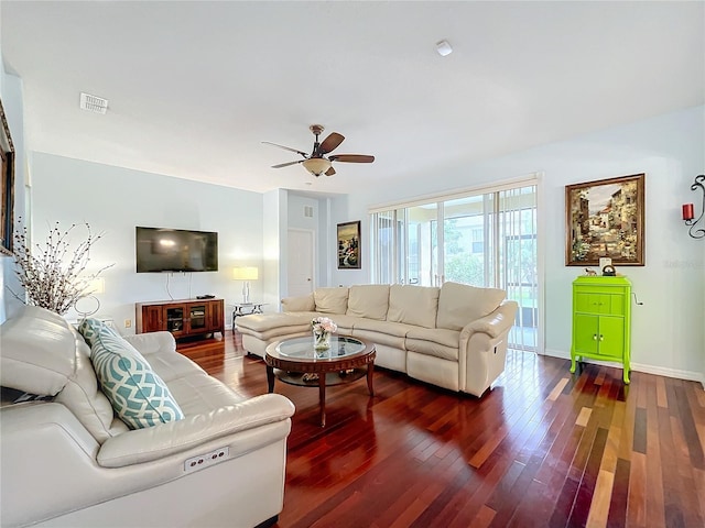 living room featuring dark wood-type flooring and ceiling fan