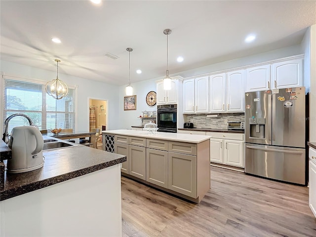 kitchen with decorative light fixtures, stainless steel fridge with ice dispenser, and light hardwood / wood-style floors