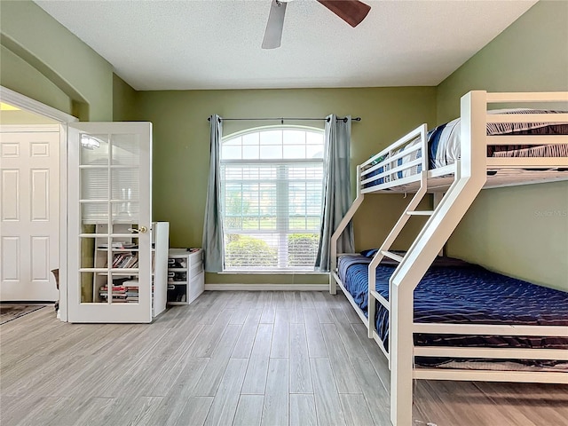 unfurnished bedroom with wood-type flooring, ceiling fan, and a textured ceiling