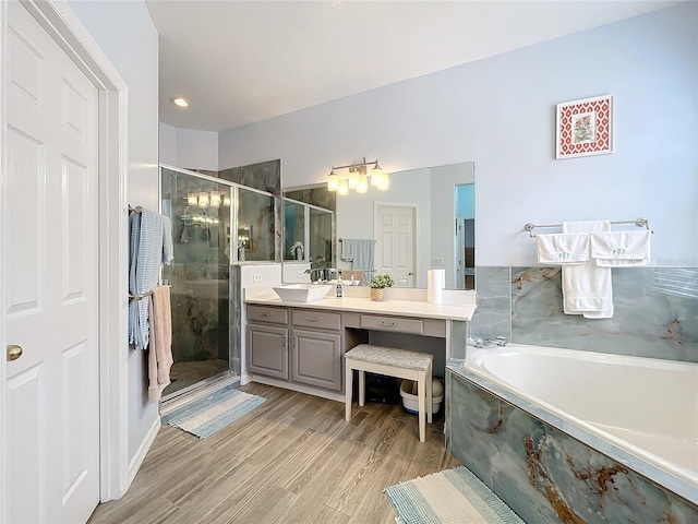 bathroom featuring shower with separate bathtub, hardwood / wood-style flooring, and vanity