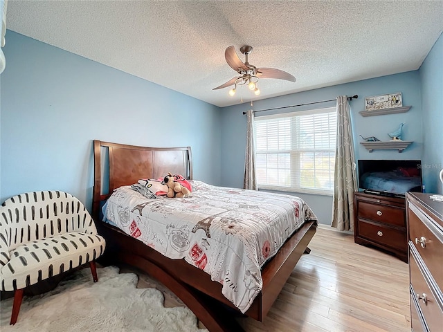 bedroom featuring a textured ceiling, light hardwood / wood-style flooring, and ceiling fan