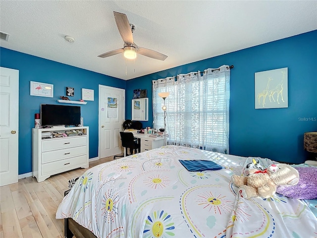 bedroom featuring light wood-type flooring, a textured ceiling, and ceiling fan