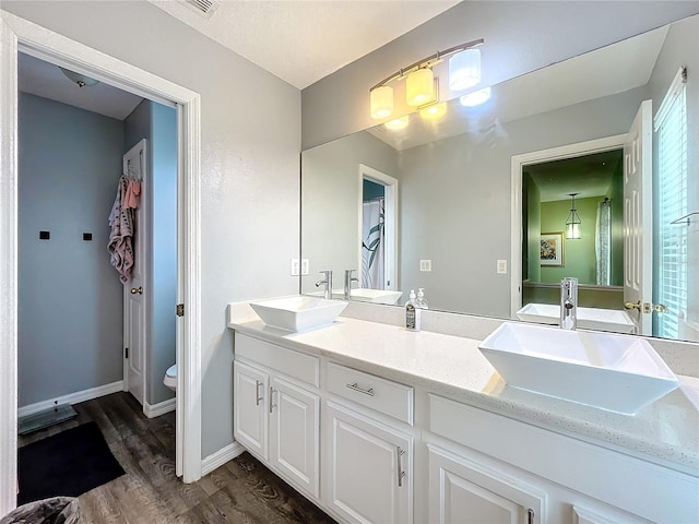 bathroom with toilet, vanity, and hardwood / wood-style flooring