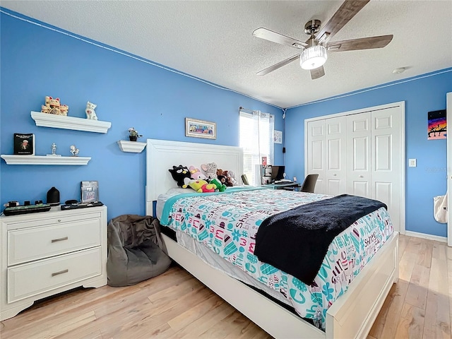 bedroom featuring ceiling fan, a textured ceiling, a closet, and light hardwood / wood-style flooring