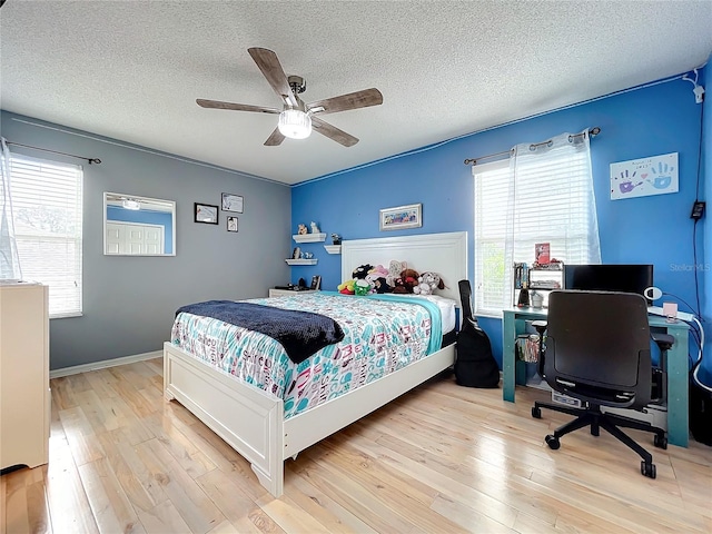 bedroom featuring a textured ceiling, light wood-type flooring, and ceiling fan