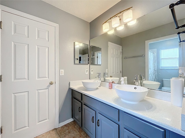 bathroom featuring tile patterned flooring, vanity, and toilet