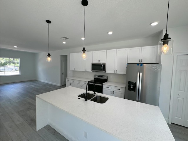 kitchen with white cabinets, sink, decorative light fixtures, and appliances with stainless steel finishes