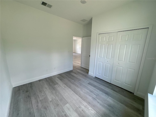 unfurnished bedroom featuring light hardwood / wood-style flooring and a closet