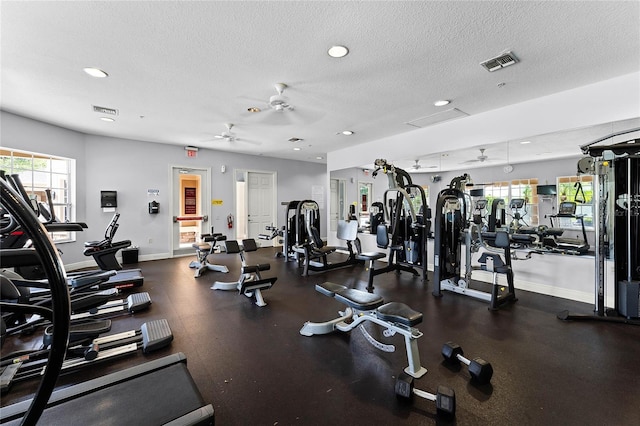 gym with a textured ceiling and ceiling fan