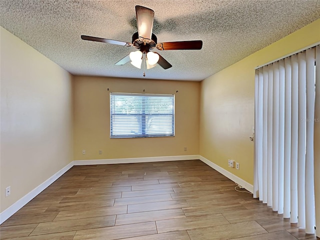 empty room featuring light wood-type flooring, a textured ceiling, and ceiling fan