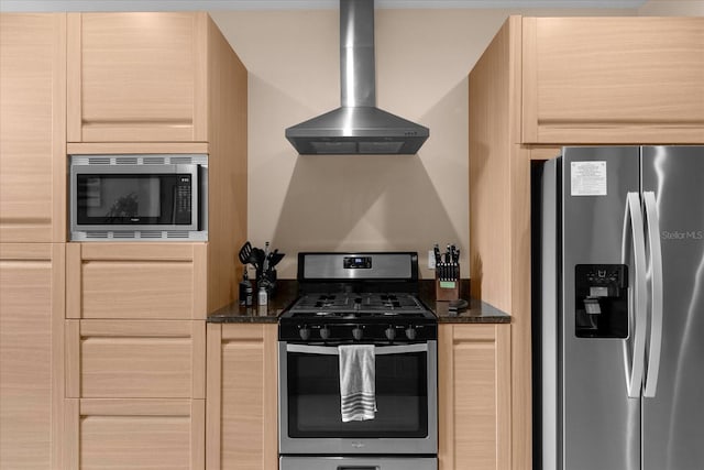 kitchen with light brown cabinets, range hood, appliances with stainless steel finishes, and dark stone counters