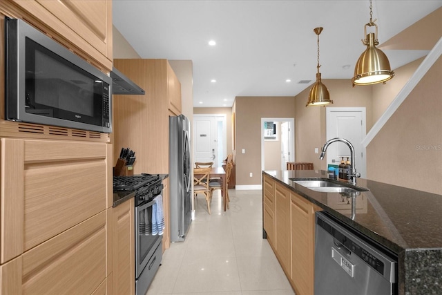 kitchen featuring sink, stainless steel appliances, an island with sink, pendant lighting, and light tile patterned floors