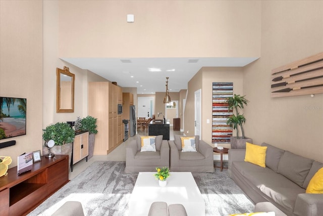 carpeted living room featuring a high ceiling