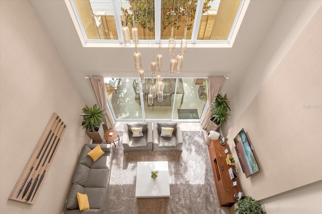 living room featuring a notable chandelier and a high ceiling