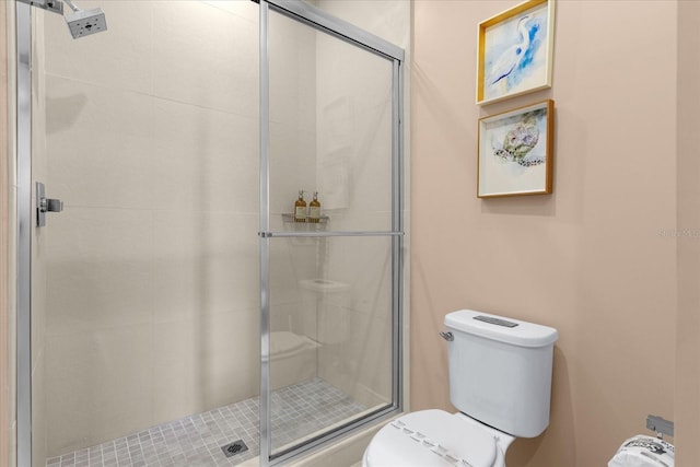 bathroom featuring walk in shower and toilet