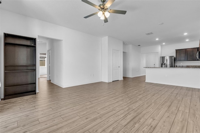 unfurnished living room featuring ceiling fan and light wood-type flooring