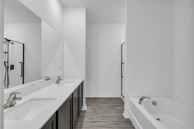 bathroom with vanity, wood-type flooring, and shower with separate bathtub