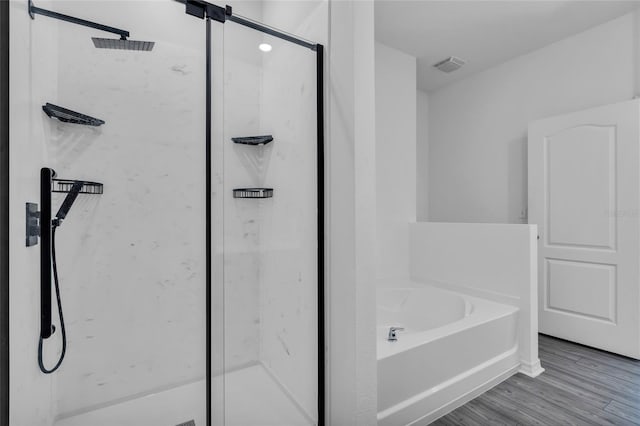 bathroom featuring shower with separate bathtub and hardwood / wood-style floors