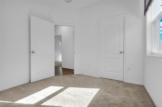 unfurnished bedroom with carpet flooring and multiple windows