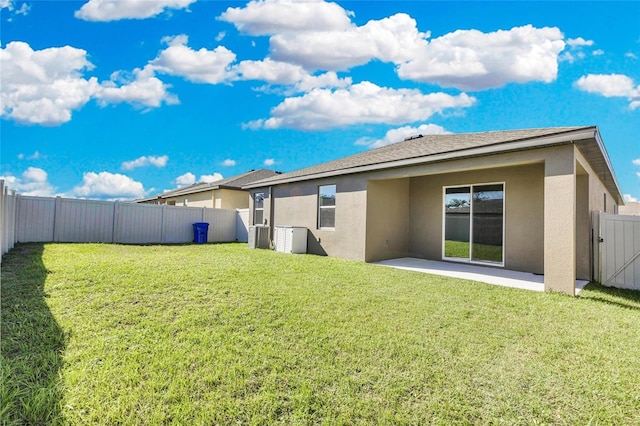 back of house with a patio and a yard