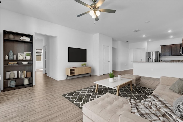 living room featuring ceiling fan and light wood-type flooring