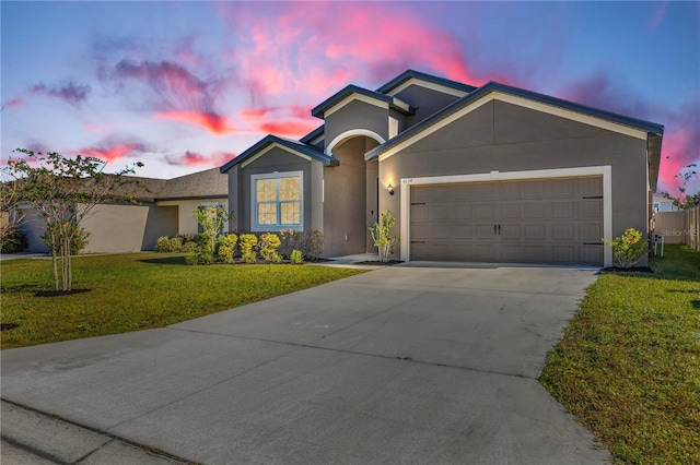 ranch-style house with a garage and a lawn