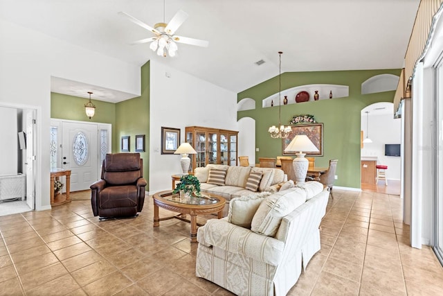 living room with ceiling fan with notable chandelier, light tile patterned floors, and high vaulted ceiling