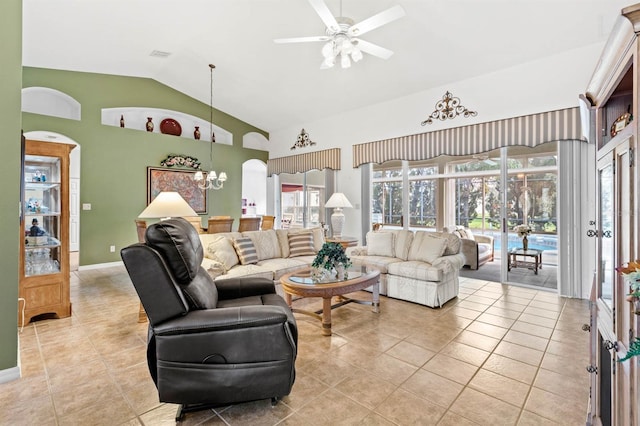 living room featuring ceiling fan with notable chandelier, vaulted ceiling, and light tile patterned flooring